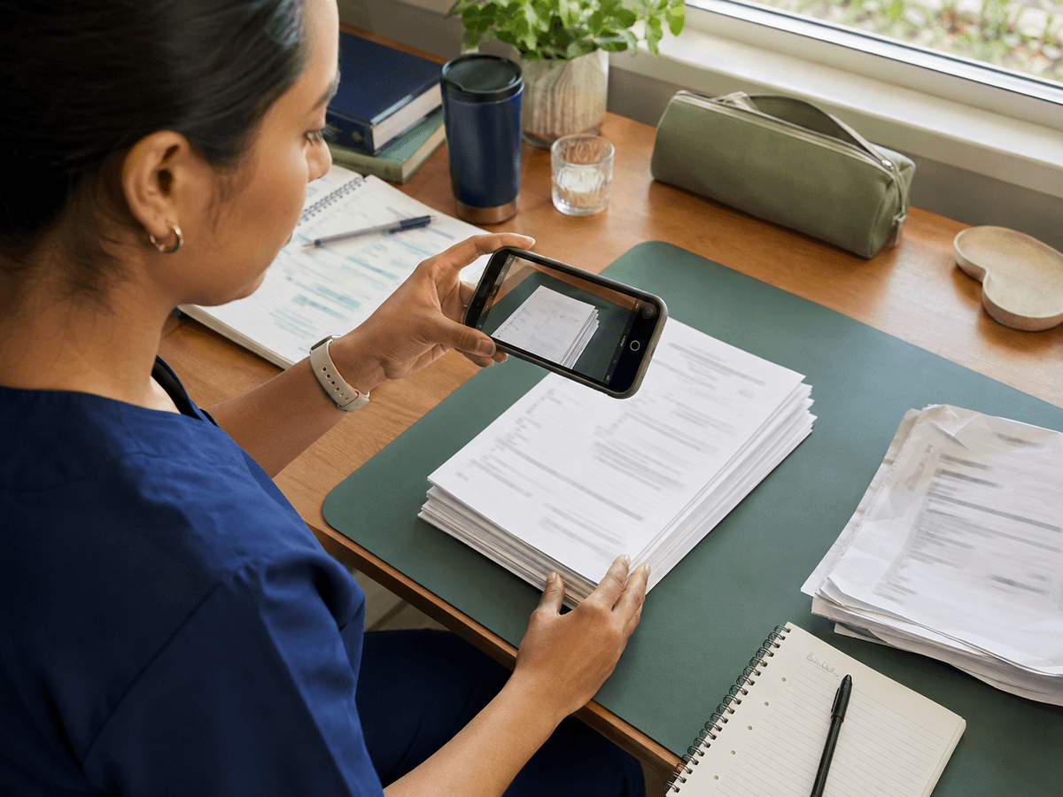 Person photographing clinical placement documents for digital upload